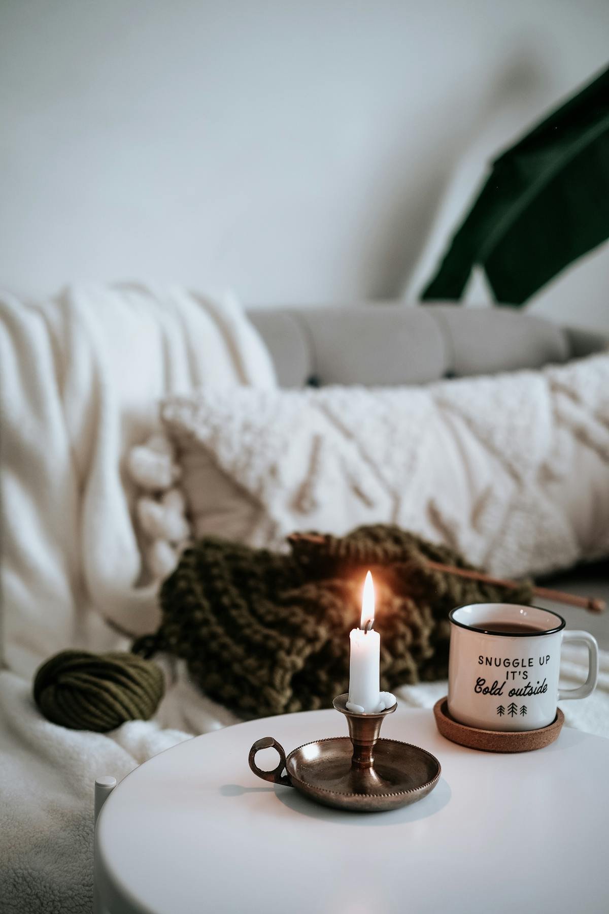 Sala de estar aconchegante com velas acesas e caneca quente, estilo hygge